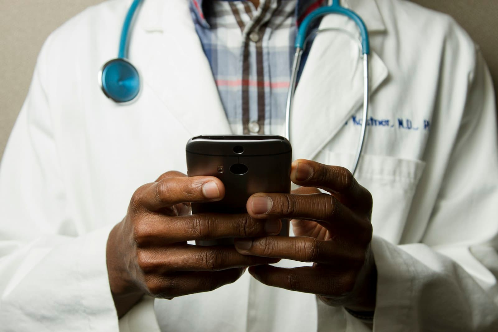 Doctor in a white coat using a mobile device